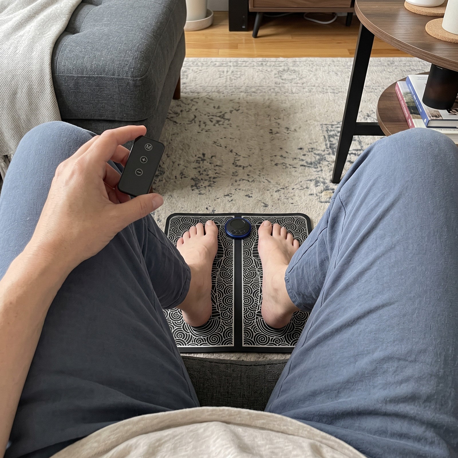 Owner view of bare feet on FootPause at a daytime sofa